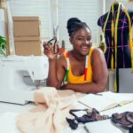 Young african american dressmaker woman sews clothes