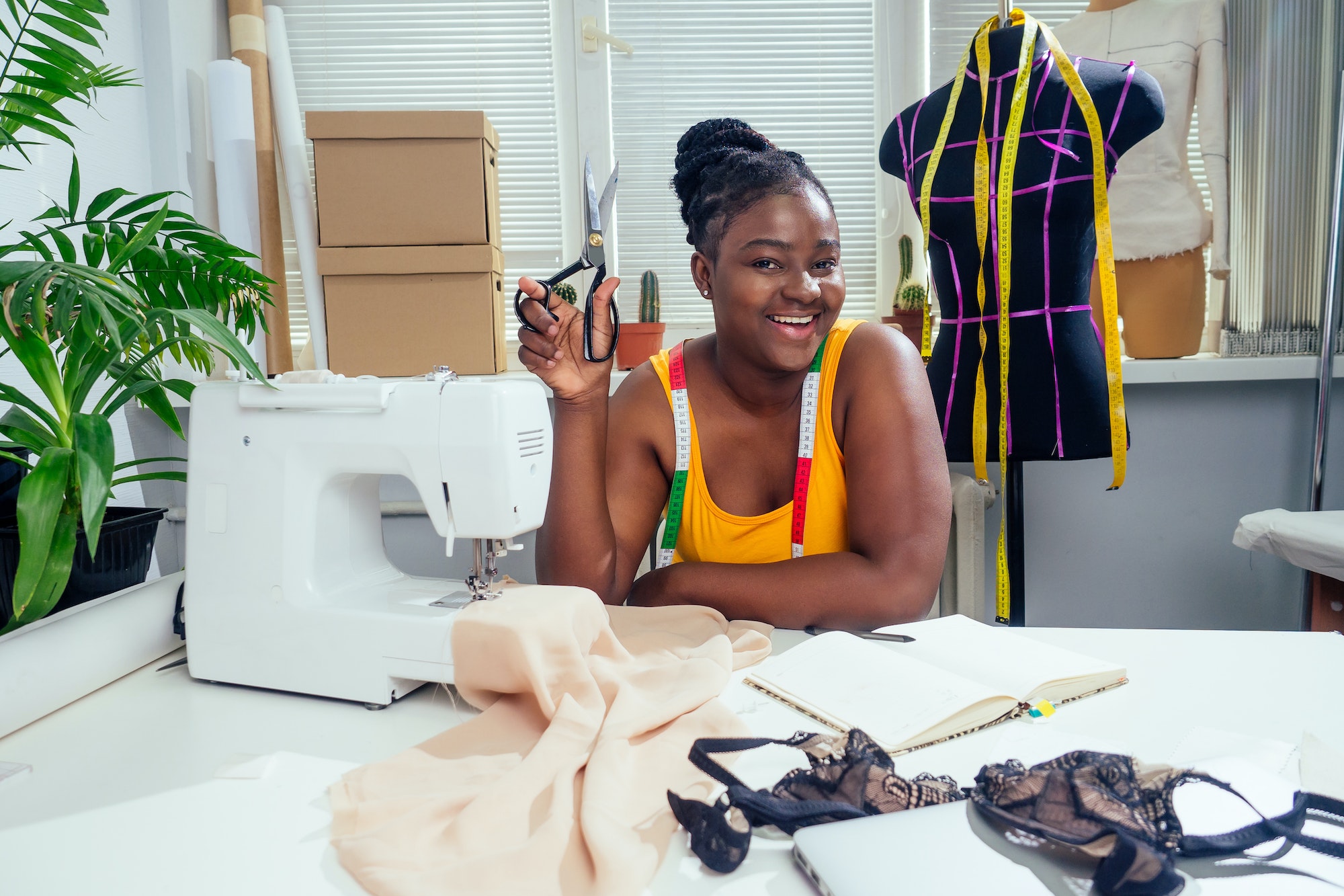 Young african american dressmaker woman sews clothes