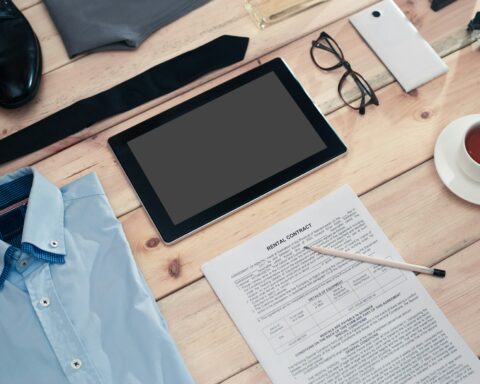 Rental contract and business accessories on wooden table.