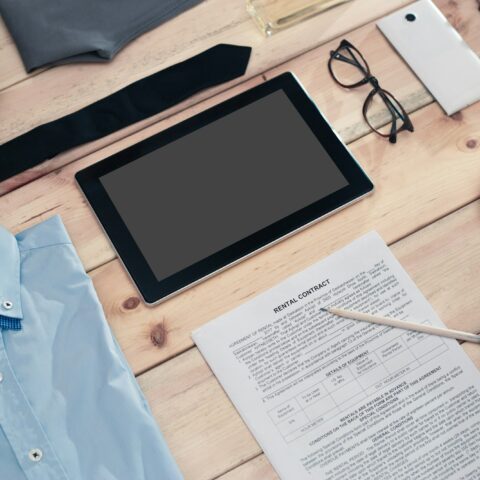 Rental contract and business accessories on wooden table.