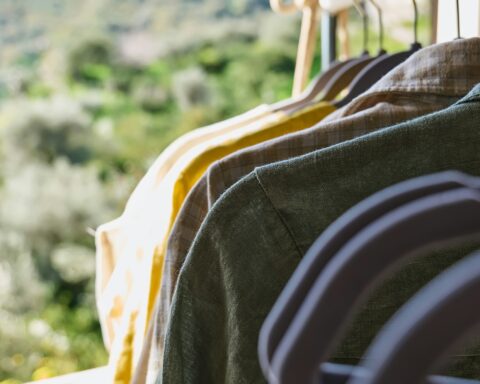 Linen clothes on gray hangers on the clothes rack. Slow Fashion. Sustainable seasonal Sale concept.