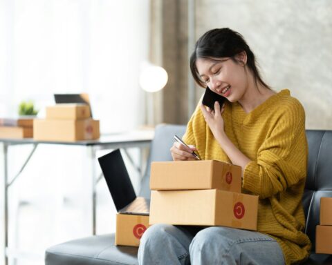 Asian woman business owner works with a box at home, prepare parcel delivery SME supply chain.