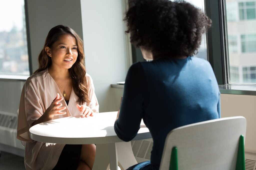 Two office employees discussing the importance of knowledge management while fostering a culture of knowledge sharing.