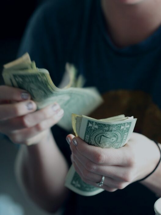 focus photography of person counting dollar banknotes