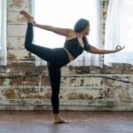 woman in black tank top and leggings doing yoga