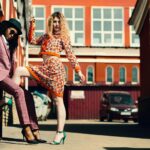 Stylish women posing in an urban alley showcasing contemporary fashion trends.