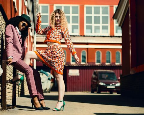 Stylish women posing in an urban alley showcasing contemporary fashion trends.