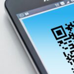 High-resolution close-up of a smartphone displaying a QR code on its screen.