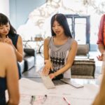 A group of women engaging in a creative discussion in a modern office setting.