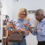 Senior couple browsing handbags in a stylish retail store in Portugal.