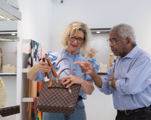 Senior couple browsing handbags in a stylish retail store in Portugal.