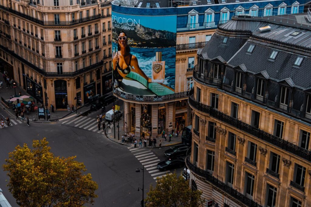 A lively urban intersection with billboards and classic architecture.