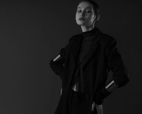 Sophisticated portrait of a woman with short hair posing elegantly in a monochrome studio setting.