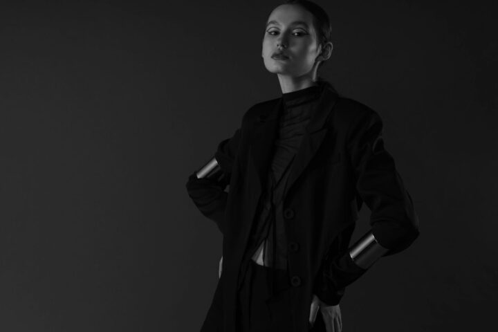 Sophisticated portrait of a woman with short hair posing elegantly in a monochrome studio setting.