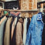 A vibrant assortment of vintage jackets hanging on a wooden rack in a boutique.