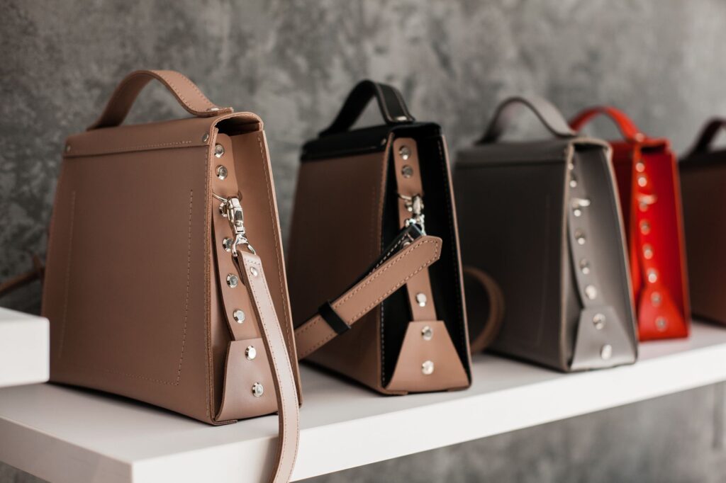 Luxury leather handbags displayed on a shelf, illustrating brand protection work in fashion law