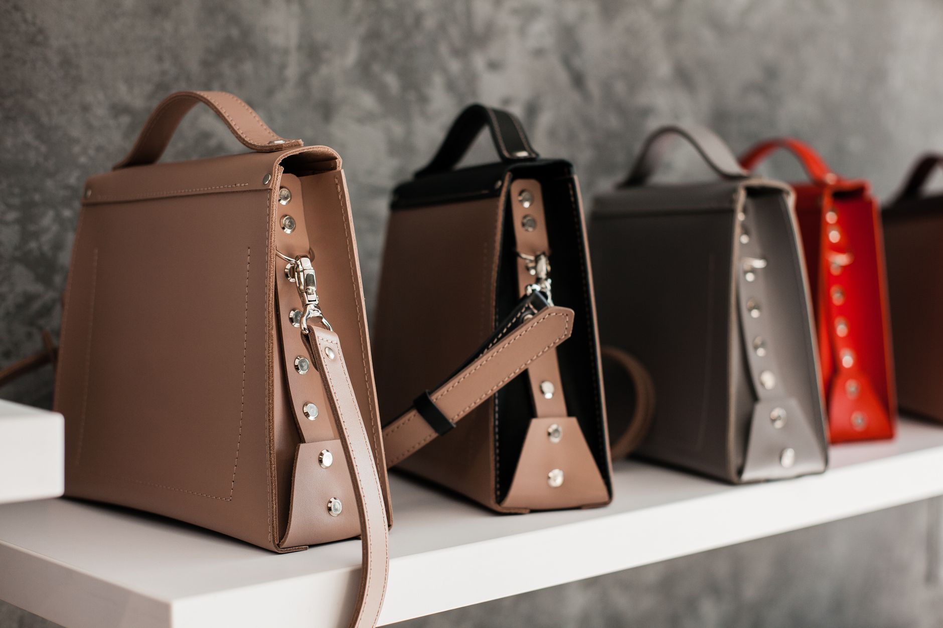 Luxury leather handbags displayed on a shelf, illustrating brand protection work in fashion law