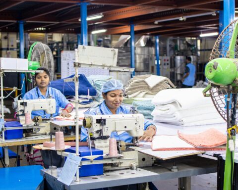Garment workers sewing in a textile factory, illustrating fashion supply chain compliance