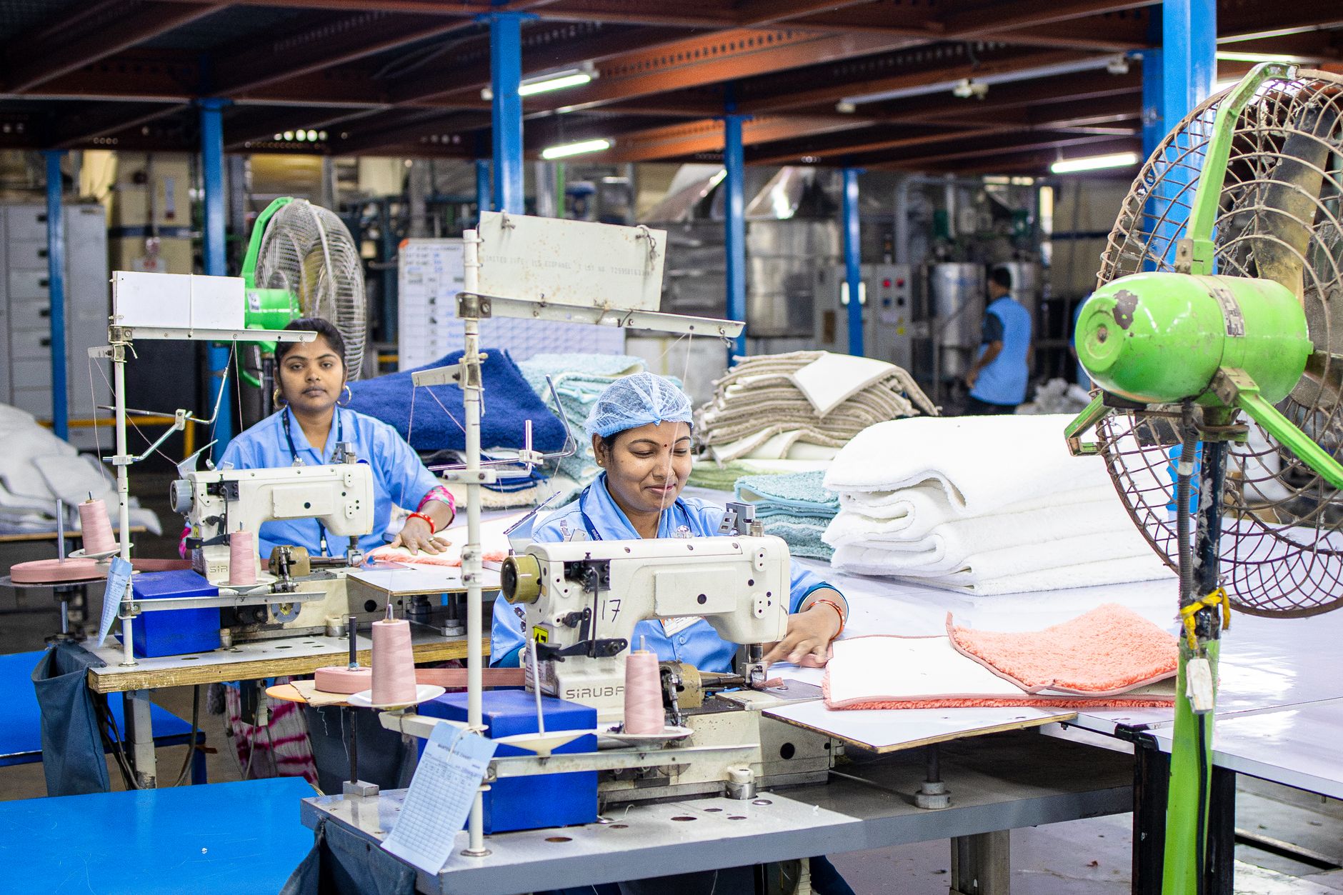 Garment workers sewing in a textile factory, illustrating fashion supply chain compliance