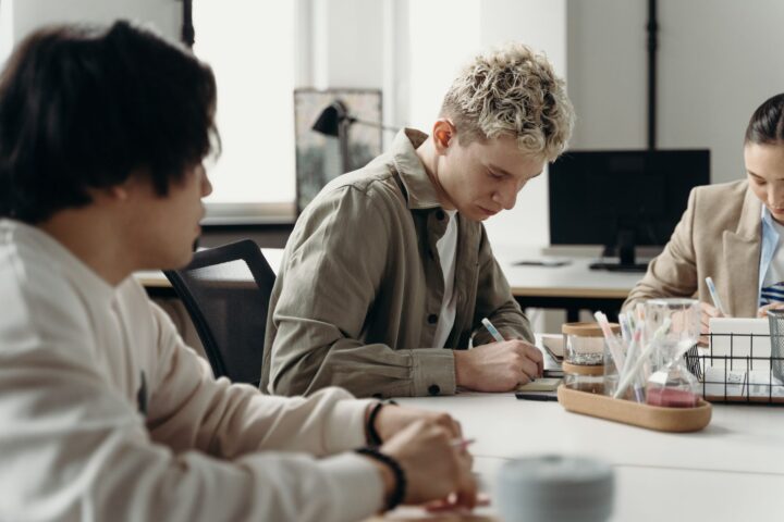 A young professional taking notes at a desk, illustrating a legal internship