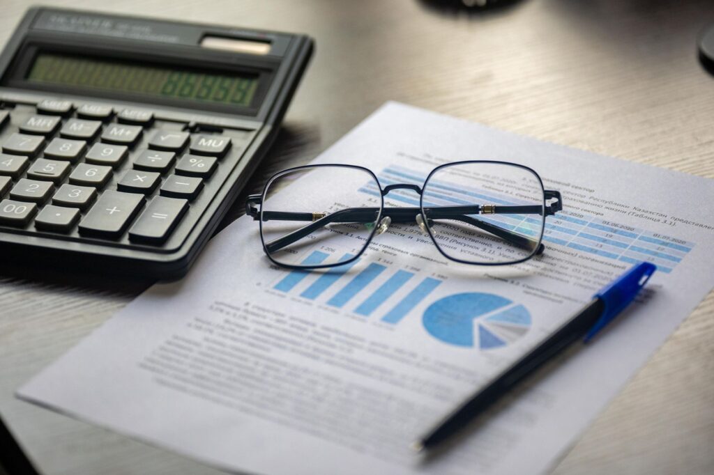 A financial document with a calculator, pen and glasses, illustrating lawyer salary data