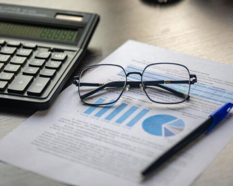 A financial document with a calculator, pen and glasses, illustrating lawyer salary data