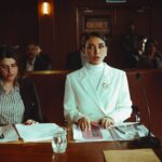Two lawyers reviewing legal documents in a courtroom, illustrating fashion litigation practice