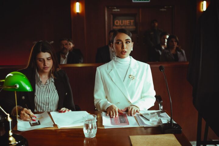 Two lawyers reviewing legal documents in a courtroom, illustrating fashion litigation practice