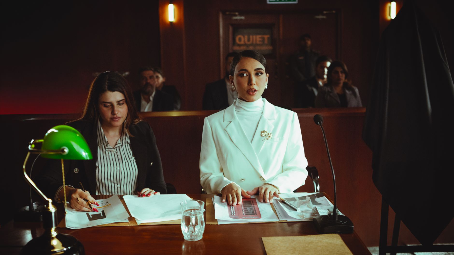 Two lawyers reviewing legal documents in a courtroom, illustrating fashion litigation practice
