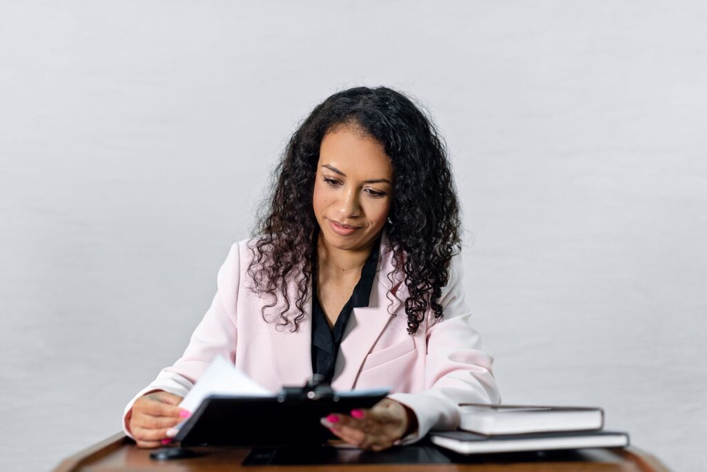 A lawyer in formal dress reviewing documents at a desk, illustrating a career in fashion law