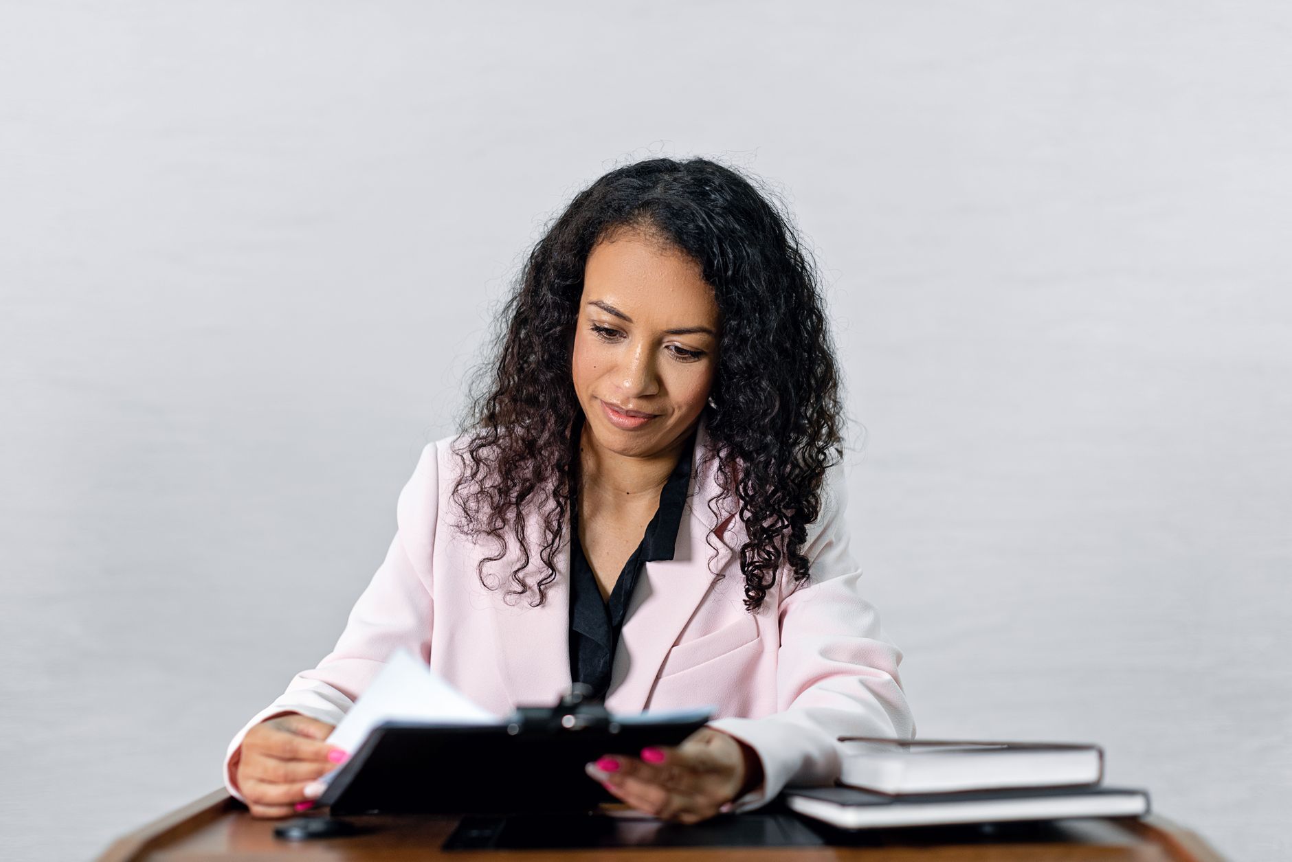A lawyer in formal dress reviewing documents at a desk, illustrating a career in fashion law