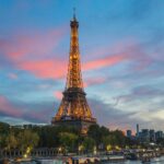 the eiffel tower is lit up at night