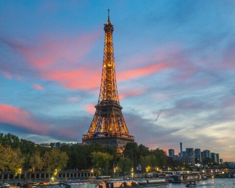 the eiffel tower is lit up at night