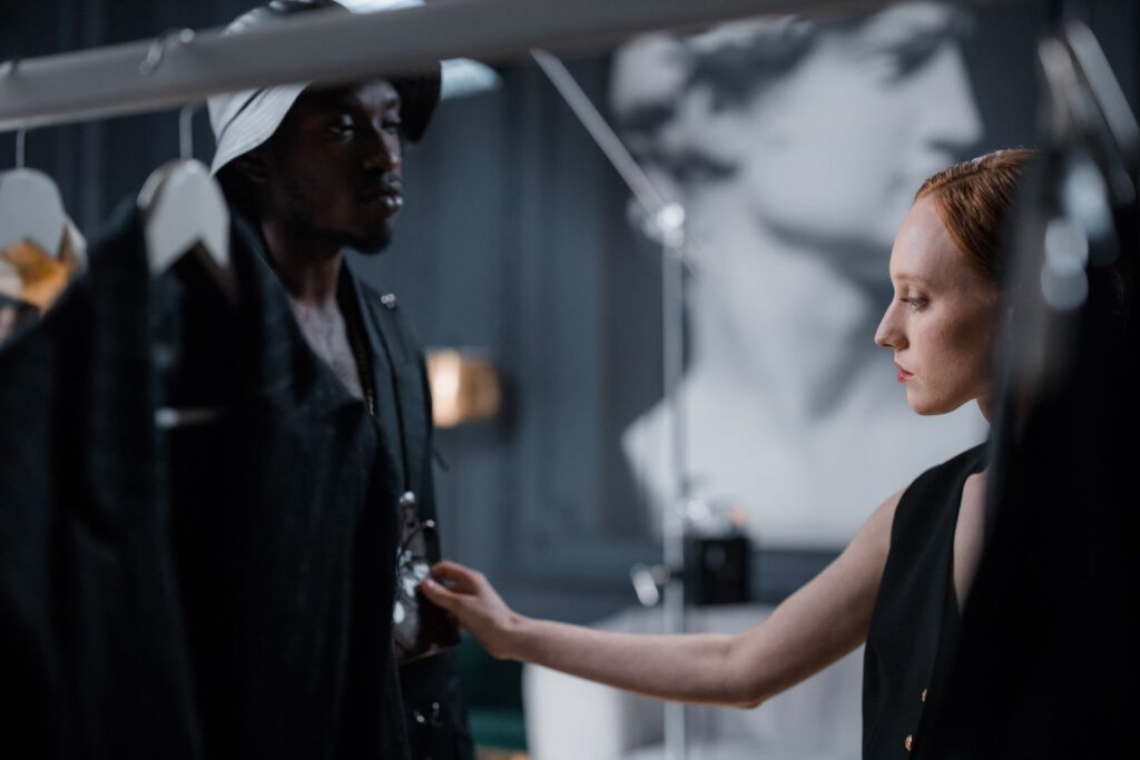 Two fashion designers fitting a garment in a studio