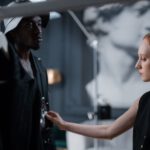 Two fashion designers fitting a garment in a studio