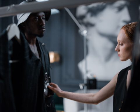 Two fashion designers fitting a garment in a studio