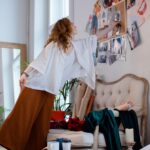 A fashion designer organizing sketches and materials in a stylish studio environment, enhancing a creative atmosphere.