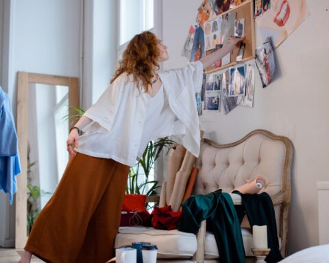 A fashion designer organizing sketches and materials in a stylish studio environment, enhancing a creative atmosphere.