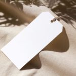 Blank white paper tag on linen fabric waiting for a clothing brand name