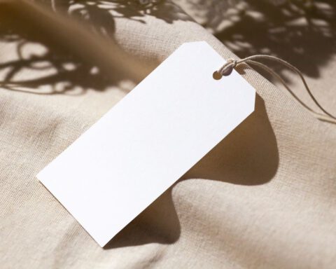 Blank white paper tag on linen fabric waiting for a clothing brand name