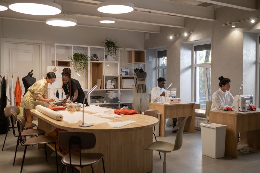 Young designers cutting patterns and sewing in a bright fashion studio, a typical setting for fashion internships