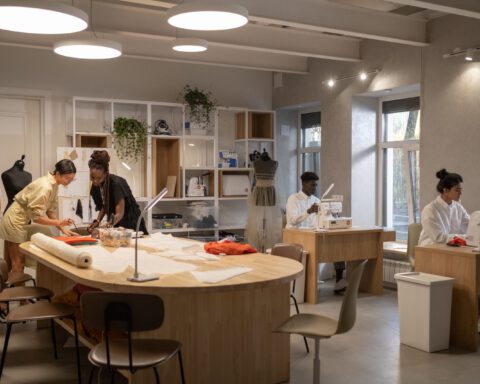 Young designers cutting patterns and sewing in a bright fashion studio, a typical setting for fashion internships