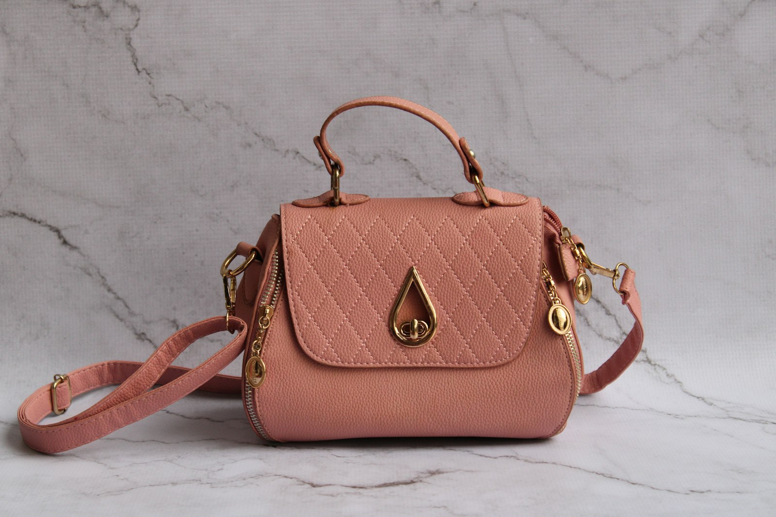 Pink leather handbag on a marble surface