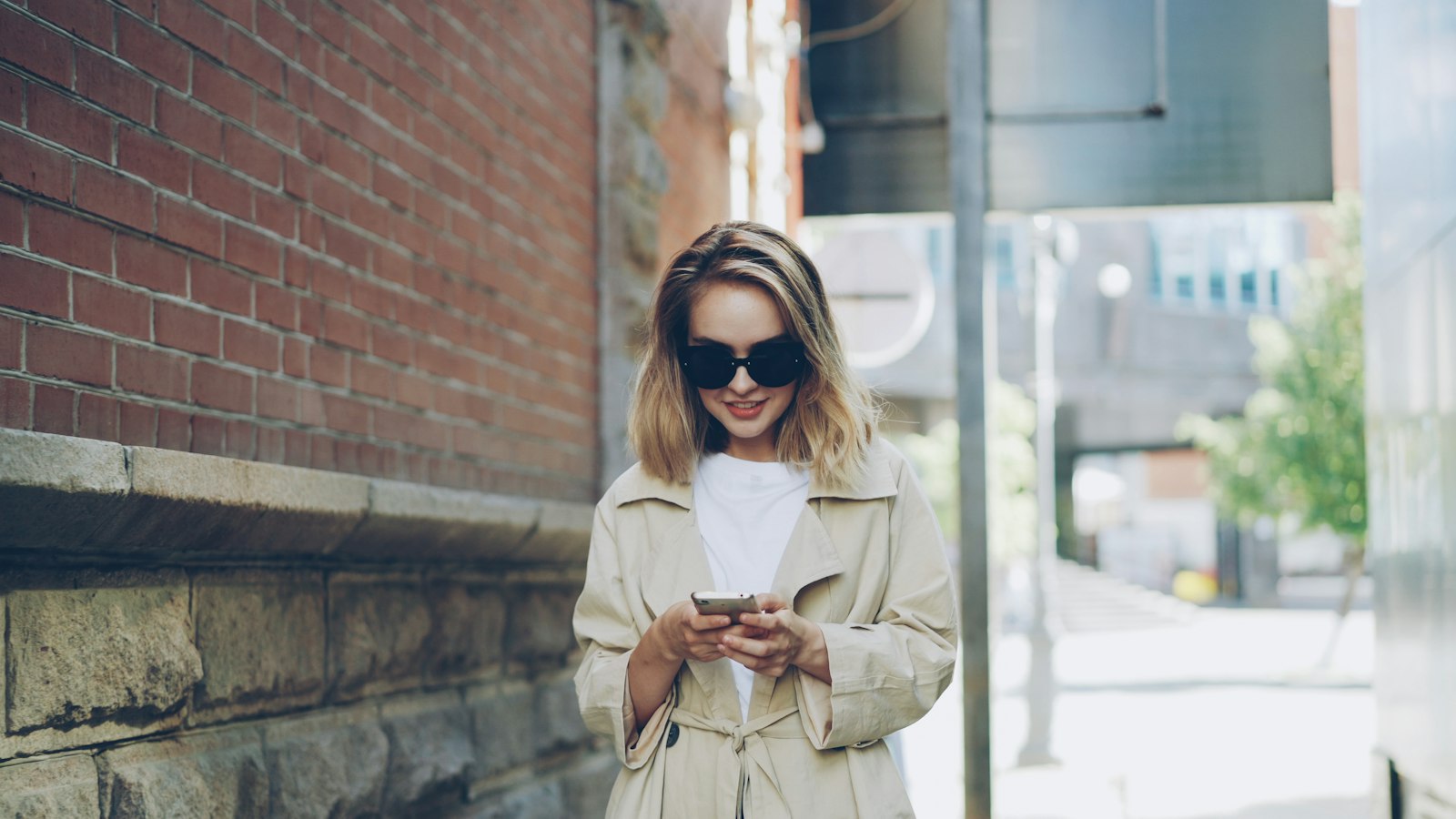 Woman in a long beige coat on a city street