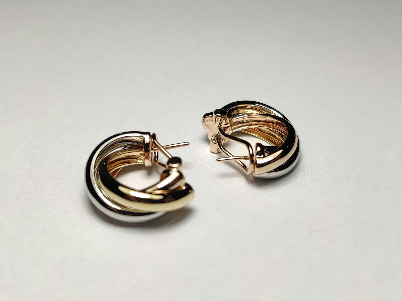 Gold hoop earrings on a white surface