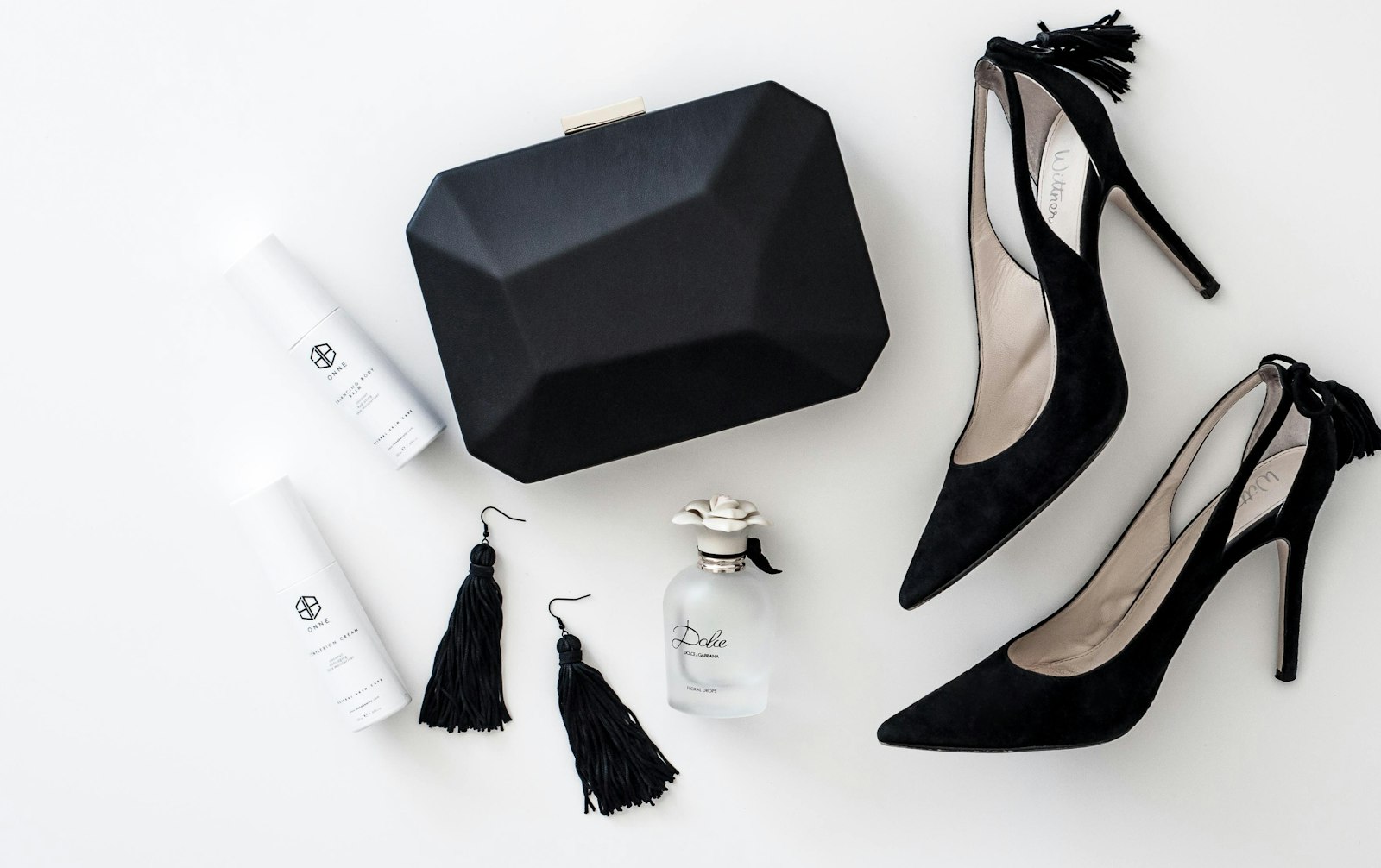Black heels and evening accessories laid out flat