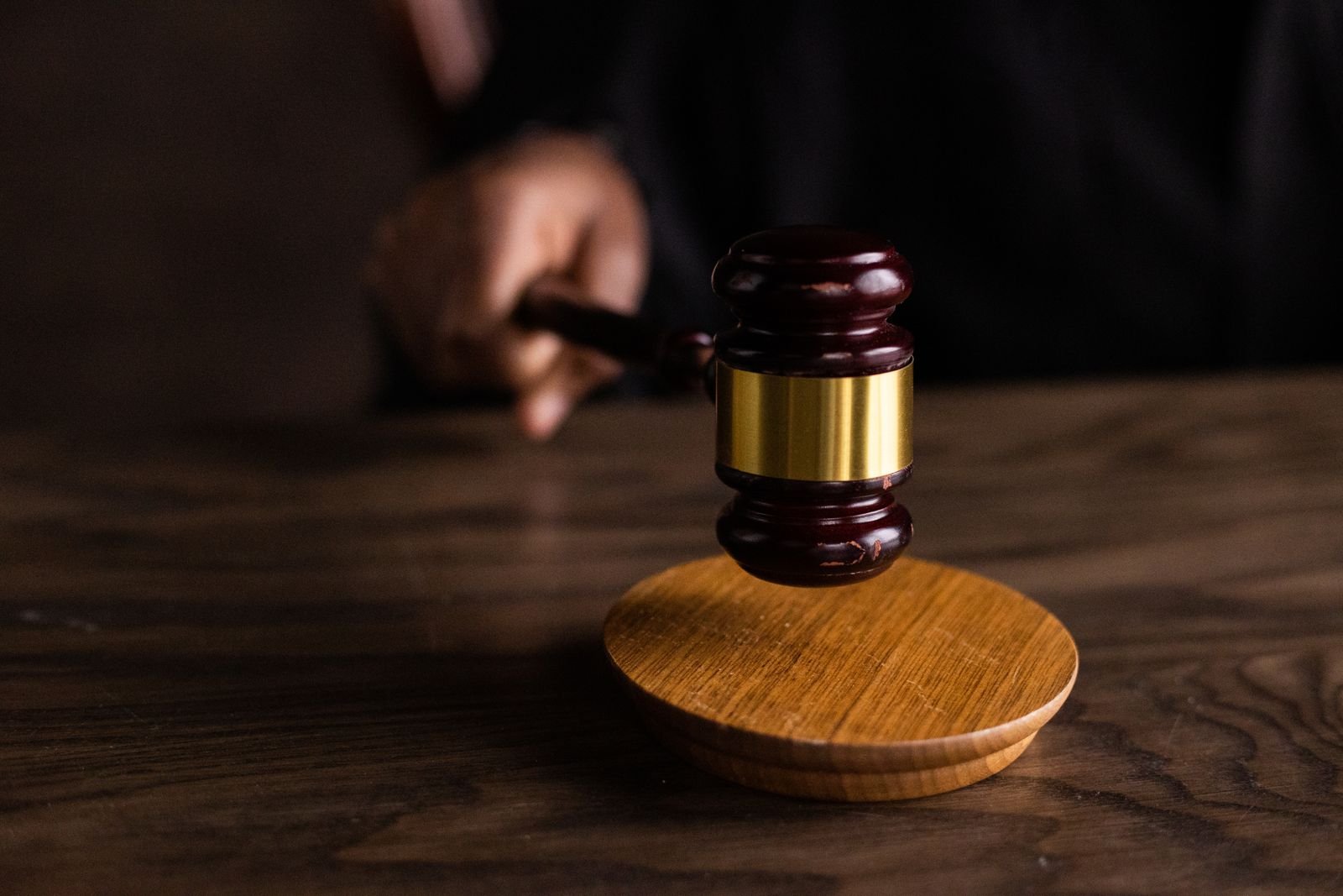 Judge's wooden gavel above a sound block on a courtroom desk, representing the Gucci logo trademark cases