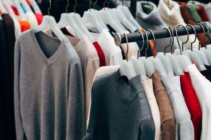 Racks of low-cost knitwear on plastic hangers, illustrating the question is Shein legit and fast fashion law