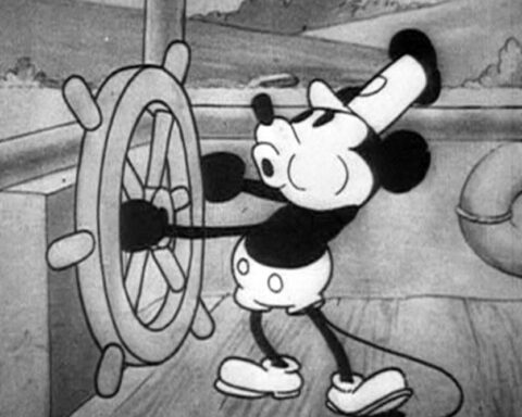 Black and white frame from the 1928 cartoon Steamboat Willie showing Mickey Mouse at a ship's wheel