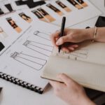 Fashion designer sketching garment designs before running a trademark search on a new brand name